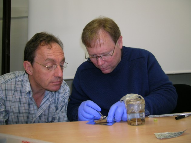 Alain Touwaide and Robert Fleischer examine a phial recovered from the wreckage.