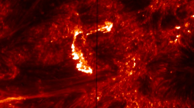 This image from the Interface Region Imaging Spectrograph (IRIS) shows emission from hot plasma in the Sun's transition region-the atmospheric layer between the surface and the outer corona. The bright, C-shaped feature at upper center shows brightening in the footprints of hot coronal loops, which is created by high-energy electrons accelerated by nanoflares. The vertical dark line corresponds to the slit of the spectrograph. The image is color-coded to show light at a wavelength of 1,400 Angstroms. The size of each pixel corresponds to about 120 km (75 miles) on the Sun.
(NASA/IRIS image)